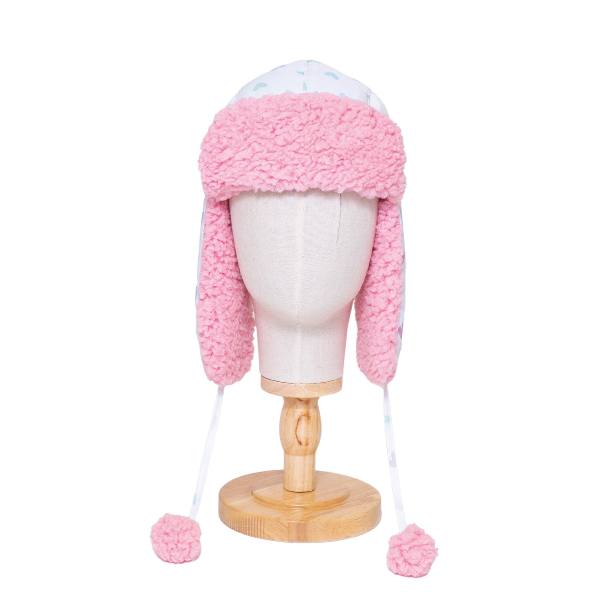 
The Cozy Trapper Hat – Hearts Print with Cosmos Pink Sherpa Liner & Pompoms