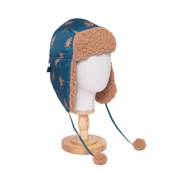 The Cozy Trapper Hat – Skating Sloths Print with Curry Tan Sherpa Liner & Pompoms